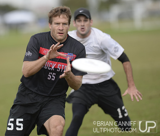 FRISCO, TX: Jared Inselmann (Chain Lightning #13) pursues receiver Trey Katzenbach (Truck Stop #55) in bracket play at the USA Ultimate Men's National Championships. Friday, October 18, 2013. ©  Brian